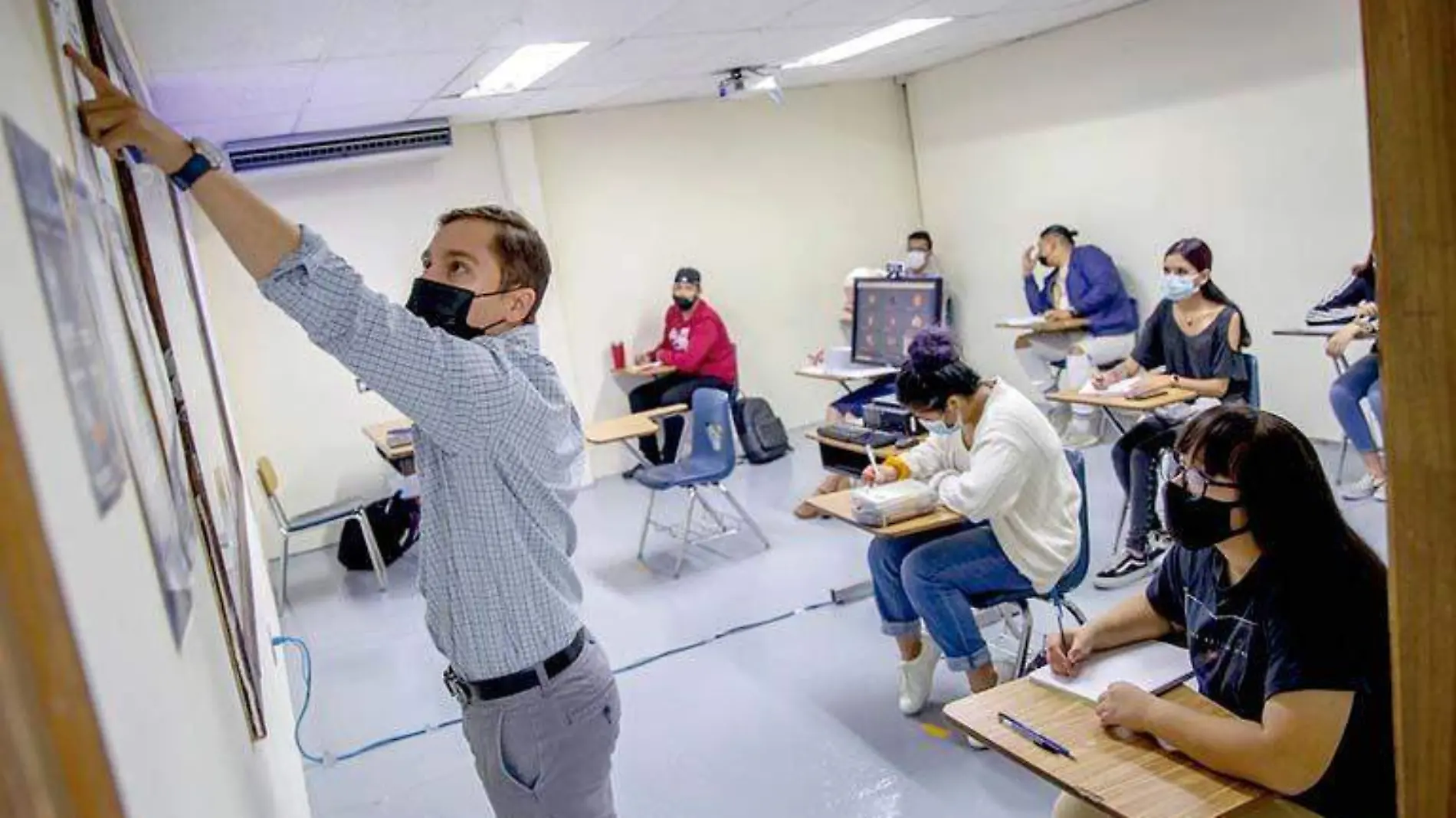 profesor señalando el pintarrón durante una clase